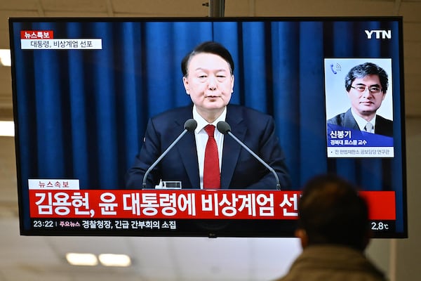 A man watches South Korea's President Yoon Suk Yeol speak during a news broadcast on a television at a train station in Seoul on Dec. 3, 2024, after he declared emergency martial law, saying the step was necessary to protect the country from "communist forces" amid parliamentary wrangling over a budget bill. "To safeguard a liberal South Korea from the threats posed by North Korea's communist forces and to eliminate anti-state elements ... I hereby declare emergency martial law," Yoon said in a live televised address to the nation. (Anthony Wallace/AFP via Getty Images/TNS)