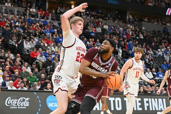 Montana forward Te'Jon Sawyer, right, drives to the basket as Wisconsin forward Steven Crowl defends during the first half in the first round of the NCAA college basketball tournament Thursday, March 20, 2025, in Denver. (AP Photo/John Leyba)