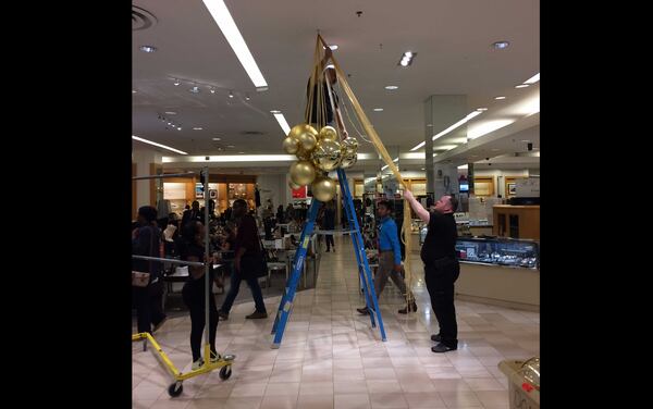 A person hangs decorations in Perimeter Mall on Oct. 28. (BECCA GODWIN / BECCA.GODWIN@AJC.COM)