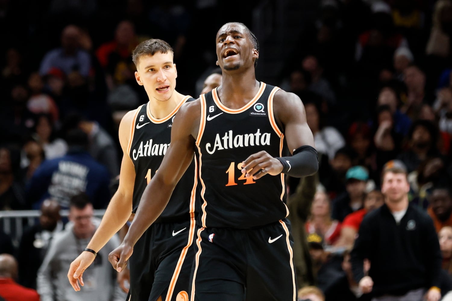 Hawks guard Bogdan Bogdanovic reacts with forward AJ Griffin after he scored a three-pointer during the second half against the Magic on Monday night in Atlanta. (Miguel Martinez / miguel.martinezjimenez@ajc.com)