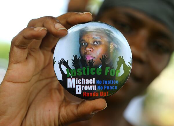 A protestor holds a button in support of Michael Brown in Ferguson. (CURTIS COMPTON / CCOMPTON@AJC.COM)