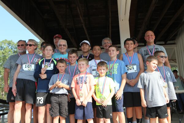 Jimmy Carter poses at the Plains Train Depot with male age group winners in a road race during last weekend's 21st Annual Plains Peanut Festival. Photo by Jill Stuckey