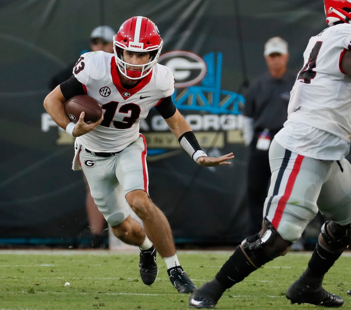 10/30/21 - Jacksonville - Georgia Bulldogs quarterback Stetson Bennett (13) scrambles for a first down during the second half of the annual NCCA  Georgia vs Florida game at TIAA Bank Field in Jacksonville. Georgia won 34-7.  Bob Andres / bandres@ajc.com