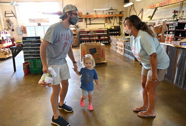 Rachel Reece (right), owner, helps customer Cameron Tufts, of Decatur, with his 2-year-old daughter Susie shop for apples at B.J. Reece Orchards in Ellijay. (Hyosub Shin / Hyosub.Shin@ajc.com) 