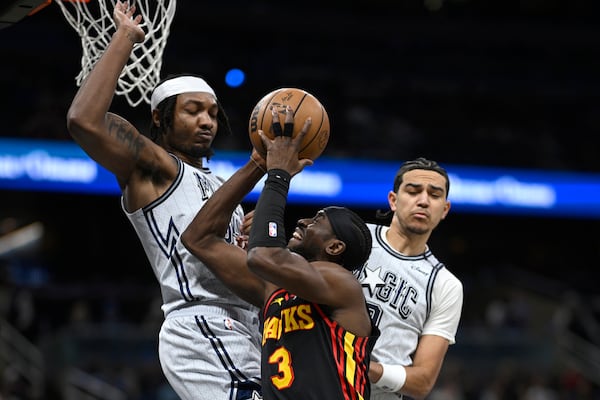 Atlanta Hawks guard Caris LeVert (3) is fouled by Orlando Magic guard Anthony Black, right, as Magic center Wendell Carter Jr. defends during the first half of an NBA basketball game, Monday, Feb. 10, 2025, in Orlando, Fla. (AP Photo/Phelan M. Ebenhack)