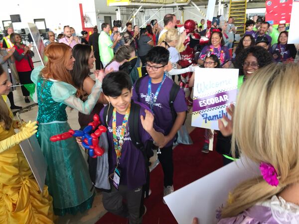  Luis Escobar and his family are greeted at the hangar before leaving for Orlando. CREDIT: Rodney Ho/rho@ajc.com