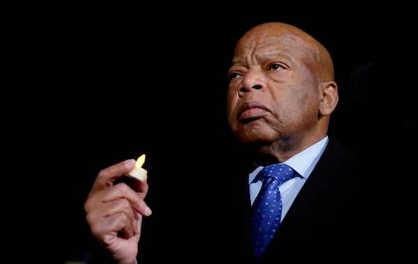 In this 2017 file photo, U.S. Rep. John Lewis, D-Atlanta, holds a candle during an event outside the U.S. Supreme Court in Washington. Lewis died in 2020.