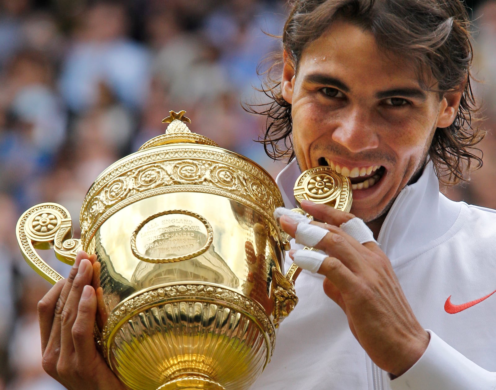 FILE - Rafael Nadal bites the trophy, after defeating Tomas Berdych in the men's singles final on the Centre Court at the All England Lawn Tennis Championships at Wimbledon, Sunday, July 4, 2010, as he has announced he will retire from tennis at age 38 following the Davis Cup finals in November. (AP Photo/Anja Niedringhaus, File)