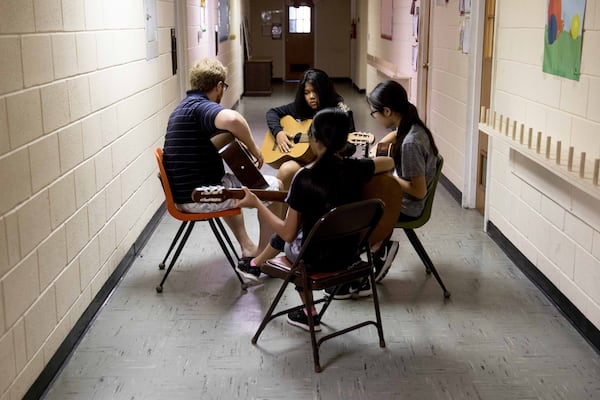 David Bentley teaches a group of girls a chord on the guitar during Free for All music lessons at Proskuneo, a music school in Clarkston that provides free lessons every Saturday morning on a variety of instruments for refugee children. Free for All lets the kids try their hand at music. BRANDEN CAMP / SPECIAL