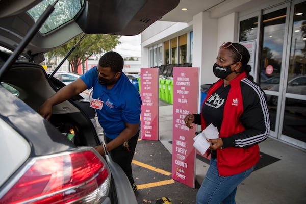 10/22/2020 - Atlanta, Georgia - Zifty contractor Anetris Austin (right) allows Tower Beer, Wine & Spirits  manager George Shelley (left) to load a customers order in her vehicle as she prepares to deliver the alcohol to a customer from Tower Beer Wine and Spirits in AtlantaÕs Lindbergh/Morosgo neighborhood, Thursday, October 22, 2020.  (Alyssa Pointer / Alyssa.Pointer@ajc.com)