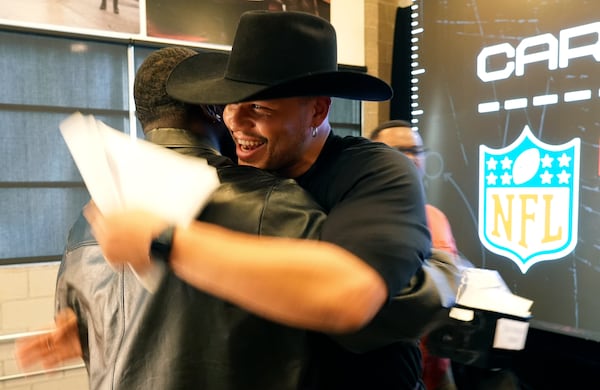 Retired NFL linebacker Brennan Scarlett, right, hugs Detroit Lions defensive end Isaac Ukwu after they finished filming a scene from "The Matrix" during a filmmaking workshop for NFL players on Tuesday, March 4, 2025, in Santa Monica, Calif. (AP Photo/Chris Pizzello)