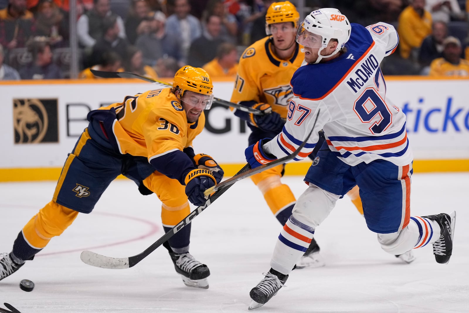 Edmonton Oilers center Connor McDavid (97) shoots the puck past Nashville Predators left wing Cole Smith (36) during the third period of an NHL hockey game Thursday, Oct. 17, 2024, in Nashville, Tenn. (AP Photo/George Walker IV)