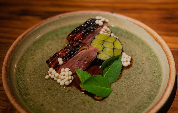 Duck with leeks and Holy Basil, topped with crisp okra seeds, at Uberto.  (Credit: Henri Hollis / henri.hollis@ajc.com)