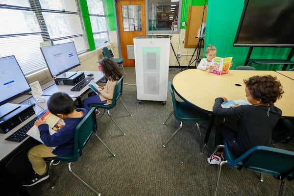 An oversized air purifier is in the media room where first grade students participate in a reading class at Ashford Park Elementary School on Thursday, Nov. 2, 2023. Every classroom in the DeKalb school district now boasts an air purifier to mitigate the risk of future COVID-19-related closures. (Miguel Martinez / miguel.martinezjimenez@ajc.com)