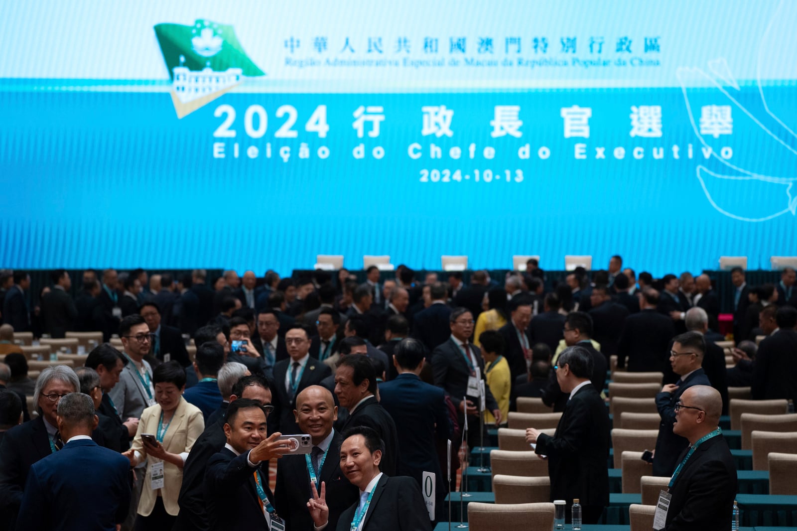 Election committee members pose for photos ahead of the chief executive election in Macao, Sunday, Oct. 13, 2024. (AP Photo/Bertha Wang)