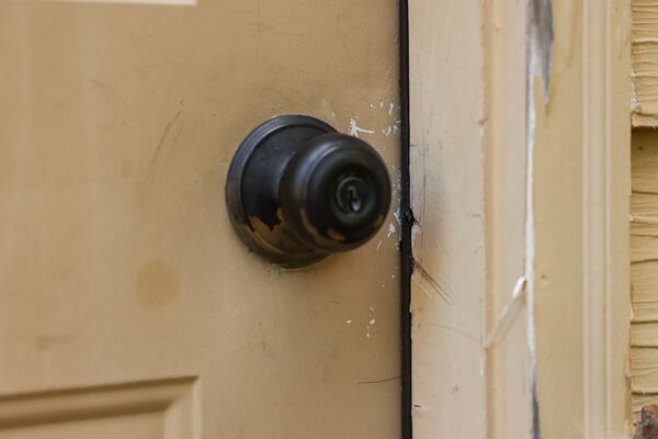 Crowbar marks are shown at the door to the garage at the Powder Springs home where a man was arrested for illegally taking up residence after it was vacated. (Jason Getz / AJC)
