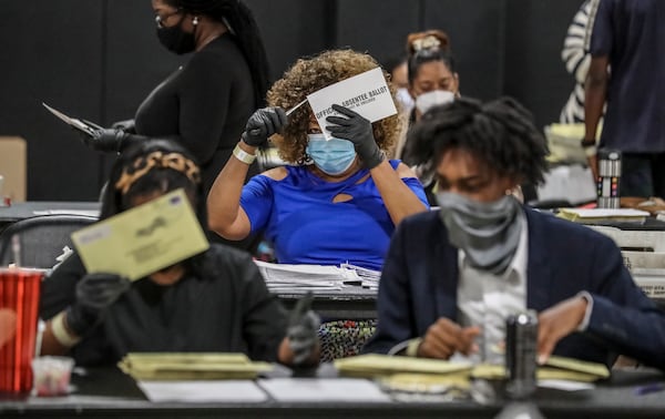 Fulton County Registration and Election Board workers process absentee ballots during the state's primary runoff earlier this month. JOHN SPINK/JSPINK@AJC.COM

