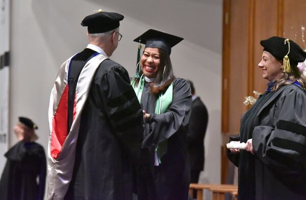 June 8, 2019 Atlanta - Kimberly Cabral (center) reacts as she receives her degree from former President of Argosy University Atlanta Murray Bradfield during 2019 Argosy University Atlanta Commencement at Church of Christ at Bouldercrest in Atlanta on Saturday, June 8, 2019.  HYOSUB SHIN / HSHIN@AJC.COM