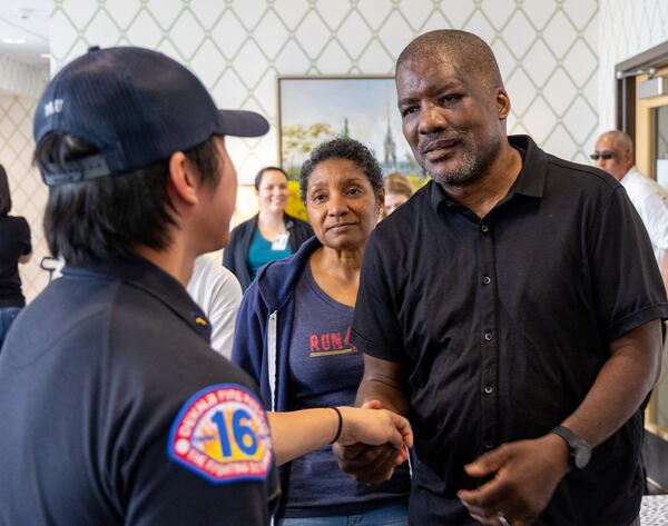 (right to left) Fulton County Fire Department Lieutenant Mark Quick and his wife Anita thank DeKalb County Fire Rescue member Nishan Mu (back to camera) who helped save Lt. Quick's life. 
 PHIL SKINNER FOR THE ATLANTA JOURNAL-CONSTITUTION