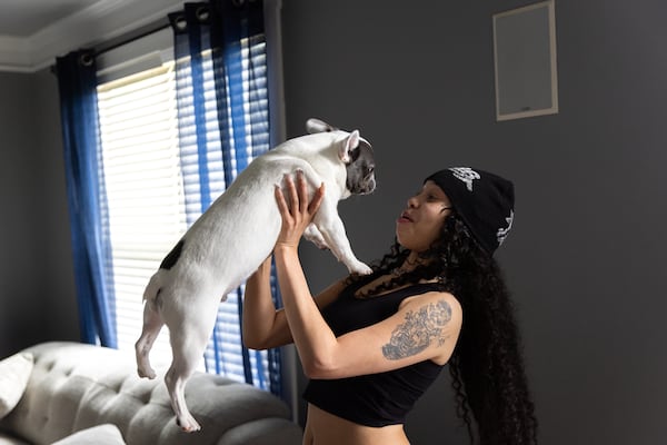 Atlanta rapper Anycia plays with her dog Rocko at her family’s home in metro Atlanta. (Arvin Temkar / AJC)