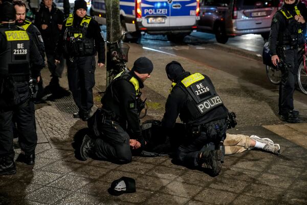 Police officers detain a man at the Holocaust memorial in Berlin, Germany, after another man was seriously injured, Friday, Feb. 21, 2025. (AP Photo/Ebrahim Noroozi)