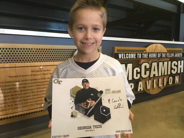 Georgia Tech fan Hudson Mitchell of Woodstock shows off the autograph he received from new Tech football coach Geoff Collins Saturday at McCamish Pavilion prior to the men's basketball team's ACC opener against Wake Forest. (AJC photo by Ken Sugiura)