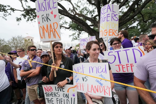 Haley Betz, Lauren Hausey and Camille Evans, veterinary technicians, protest the use of plans to use a live tiger as a mascot in the stadium, before an NCAA college football game between LSU and Alabama in Baton Rouge, La., Saturday, Nov. 9, 2024. (AP Photo/Gerald Herbert)