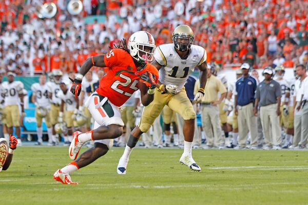 MIAMI GARDENS, FL - OCTOBER 5: Brandon Watts #11 of the Georgia Tech Yellow Jackets is unable to defend Dallas Crawford #25 of the Miami Hurricanes as he runs 17 yards for a fourth quarter touchdown on October 5, 2013 at Sun Life Stadium in Miami Gardens, Florida. The Hurricanes defeated the Yellow Jackets 45-30. (Photo by Joel Auerbach/Getty Images)