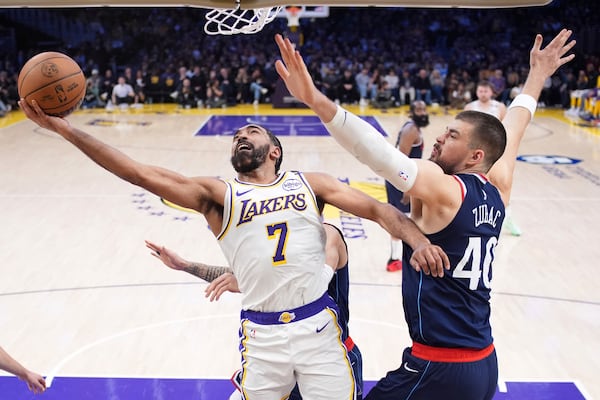 Los Angeles Lakers guard Gabe Vincent, left, shoots as Los Angeles Clippers center Ivica Zubac defends during the first half of an NBA basketball game Sunday, March 2, 2025, in Los Angeles. (AP Photo/Mark J. Terrill)