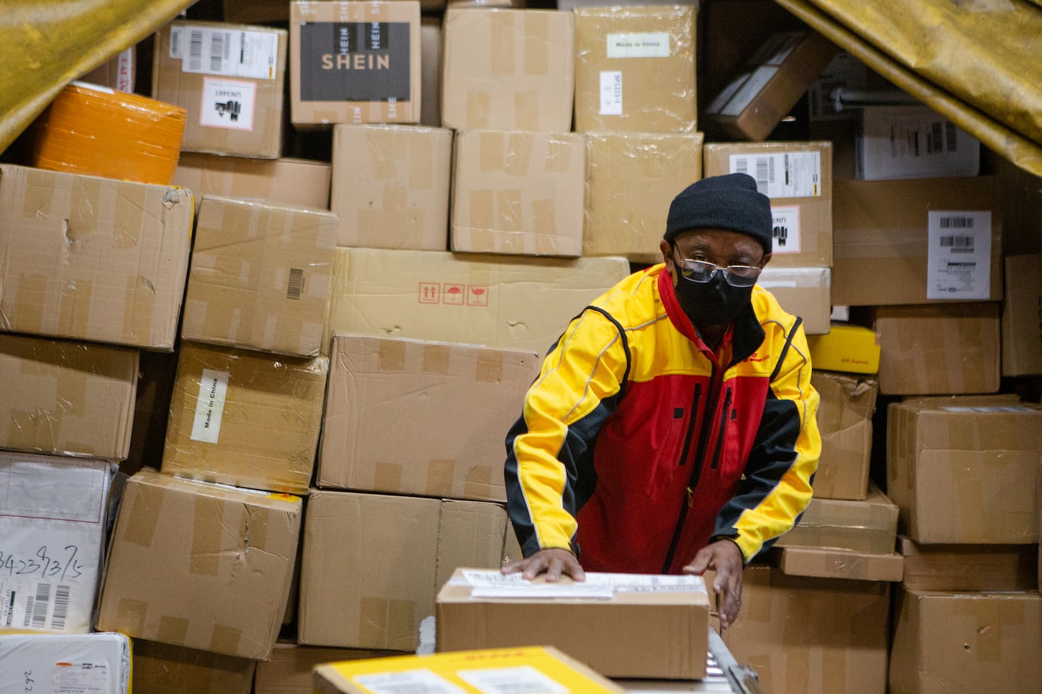 Willie Gurerra sorts packages on Wednesday, December 16, 2020, at DHL Express in Atlanta. Workers at the shipping center worked to fulfill orders during the holiday rush. CHRISTINA MATACOTTA FOR THE ATLANTA JOURNAL-CONSTITUTION.