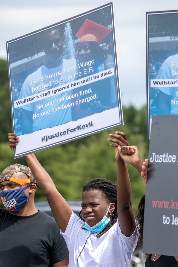 08/20/2020 - Marietta, Georgia - Kevil Wingo Jr. holds a sign featuring a photo of his father during a press conference to bring attention to his fatherÕs death outside of the Cobb County Adult Detention Center in Marietta, Thursday, August 20, 2020. Kevil Wingo died while in custody at the detention center. His family is saying that more could have been done to prevent his death. (ALYSSA POINTER / ALYSSA.POINTER@AJC.COM)