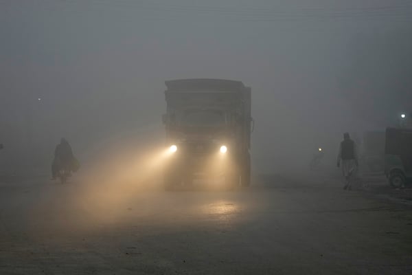 FILE - A truck moves with lights on due to smog enveloping the area of Lahore, Pakistan, Nov. 16, 2024. (AP Photo/K.M. Chaudary, File)