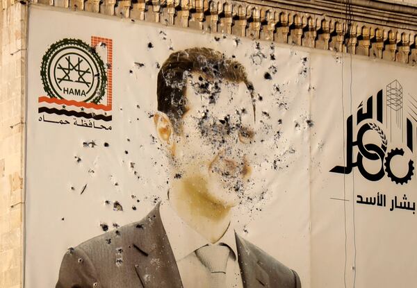 FILE - An image of ousted Syrian President Bashar Assad covers the facade of a provincial government office in the aftermath of the opposition's takeover of Hama, Syria, Dec. 6, 2024. (AP Photo/Omar Albam, File)