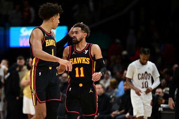 Atlanta Hawks guard Trae Young (11) is congratulated by forward Jalen Johnson after the Hawks defeated the Cleveland Cavaliers 135-124 in an NBA basketball game, Wednesday, Nov. 27, 2024, in Cleveland. (AP Photo/David Dermer)