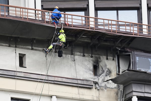 Municipal workers investigate the place after a downed Ukrainian drone damaged a building in western Moscow, Russia, Friday, March 14, 2025. (AP Photo)