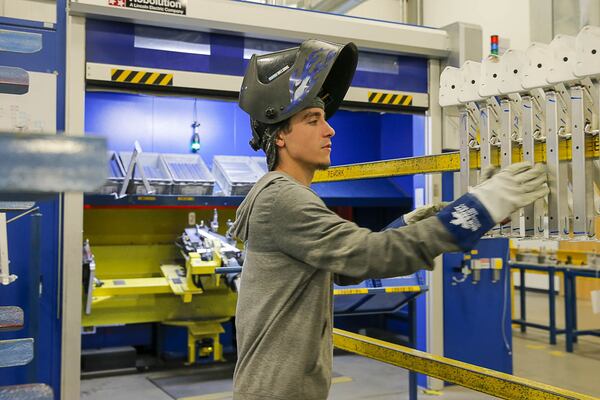 Good jobs keep local workers from leaving home. Here, Paul Musso of Hartwell, a welder, handles materials at the Linde Wiemann factory and distribution center in Lavonia. (ALYSSA POINTER/ALYSSA.POINTER@AJC.COM)