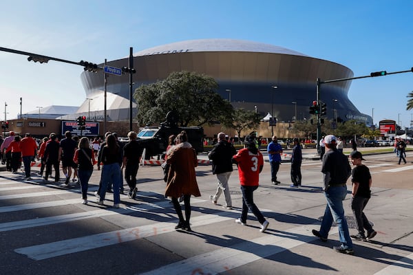 Fans walk towards the Caesars Superdome ahead of the Sugar Bowl NCAA College Football Playoff game, Thursday, Jan. 2, 2025, in New Orleans. (AP Photo/Butch Dill)