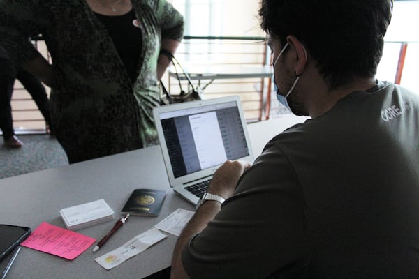 Douglas Ruano, assistant site manager with the Latin American Association, helps an attendee fill out COVID-19 vaccination paperwork, during the Association's vaccination day on Sept. 17, 2022.