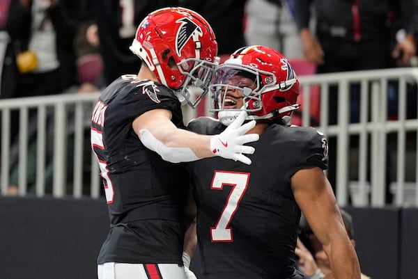 Atlanta Falcons running back Bijan Robinson (7) celebrates with Atlanta Falcons wide receiver Drake London (5) after Robinson runs in for a touchdown in the first half of an NFL football game against the New York Giants in Atlanta, Sunday, Dec. 22, 2024. (AP Photo/Mike Stewart)