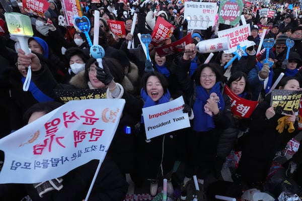 Participants react after hearing the news that South Korea's parliament voted to impeach President Yoon Suk Yeol outside the National Assembly in Seoul, South Korea, Saturday, Dec. 14, 2024. (AP Photo/Lee Jin-man)