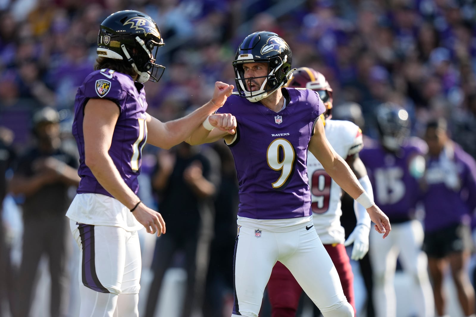 Baltimore Ravens kicker Justin Tucker (9) is congratulated by Jordan Stout after making a 39-yard field goal during the second half of an NFL football game against the Washington Commanders Sunday, Oct. 13, 2024, in Baltimore. (AP Photo/Stephanie Scarbrough)