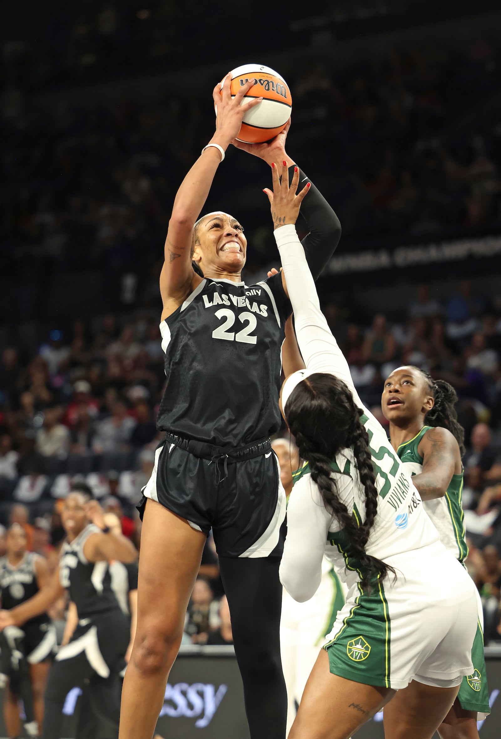 Las Vegas Aces center A'ja Wilson (22) goes up to shoot around Seattle Storm guards Victoria Vivians (35) and Jewell Loyd (24) during a first-round WNBA basketball playoff game Sunday, Sept. 22, 2024, in Las Vegas. (AP Photo/Ronda Churchill)