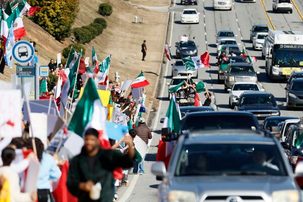 People wave Mexican flags as they ride along Buford Highway. On Saturday, February 1, 2025, protesters chanted on the sidewalks of Plaza Fiesta in response to a recent immigration arrest in Georgia. 
(Miguel Martinez/ AJC)