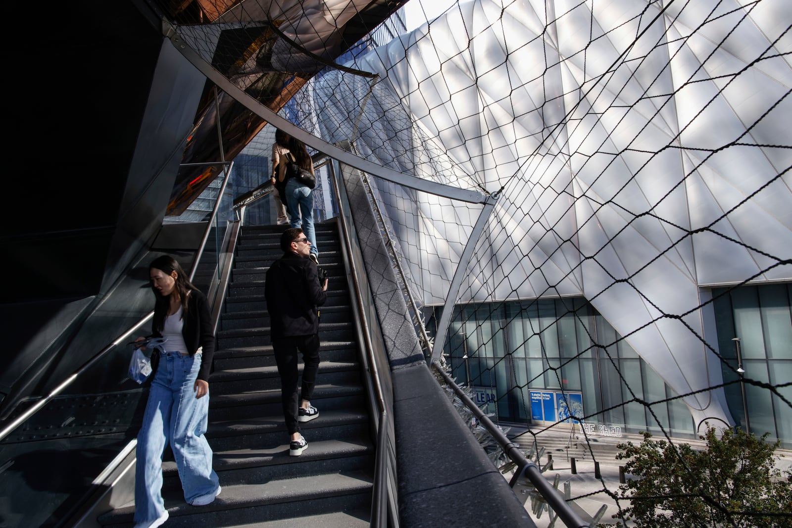 An exterior net covers the structure while people visit the Vessel as it reopens with safety features in New York, Monday, Oct. 21, 2024. (AP Photo/Kena Betancur)