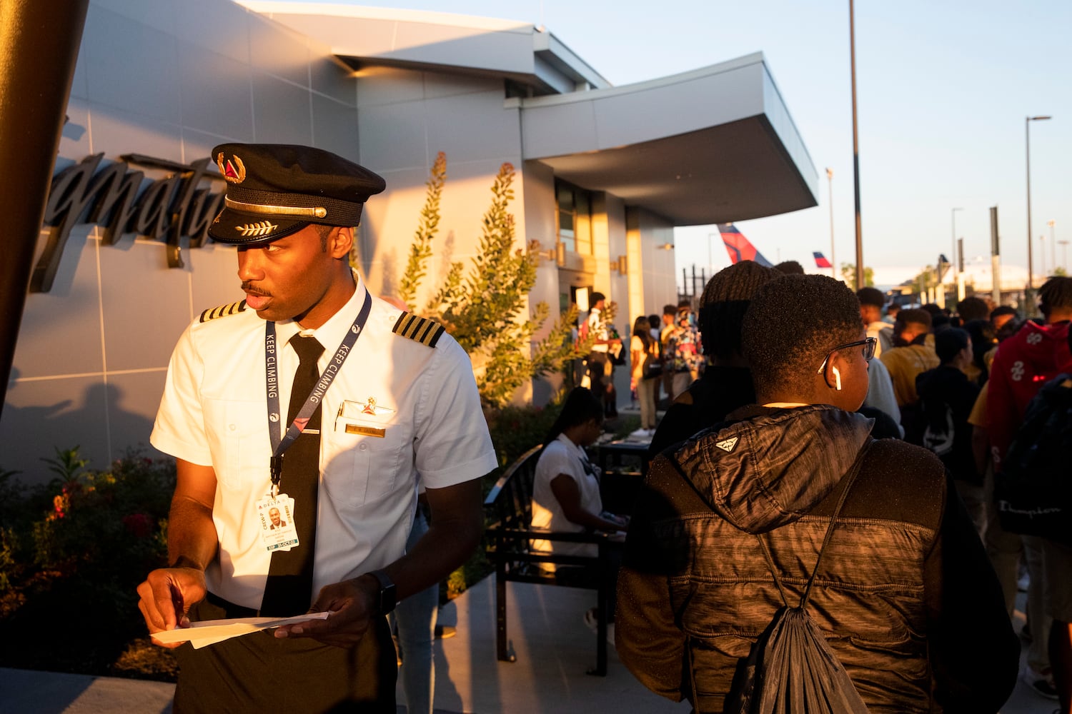 Kyle Greene, a captain with Delta Airlines, organizes participants of Delta’s Dream Flight 2022 event as they line up to pass through security at Hartsfield-Jackson Atlanta International Airport on Friday, July 15, 2022. Around 150 students ranging from 13 to 18 years old will fly from Atlanta to the Duluth Air National Guard Base in Duluth, Minnesota. Greene participated in the program himself when he was a teenager. (Chris Day/Christopher.Day@ajc.com)