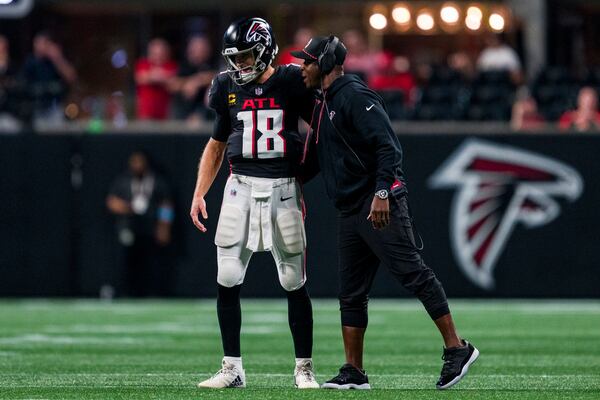 Atlanta Falcons head coach Raheem Morris talks with quarterback Kirk Cousins (18) during the second half of an NFL football game against the Kansas City Chiefs, Sunday, Sept. 22, 2024, in Atlanta. The Chiefs defeated the Falcons 22-17. (AP Photo/Danny Karnik)