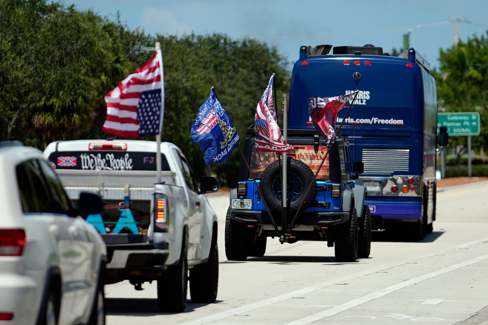 Trump supporters who turned out to protest against abortion follow the bus at the start of the "Reproductive Freedom Bus Tour" by the campaign of Democratic presidential nominee Vice President Kamala Harris and running mate Gov. Tim Walz, Tuesday, Sept. 3, 2024, in Boynton Beach, Fla. (AP Photo/Rebecca Blackwell)