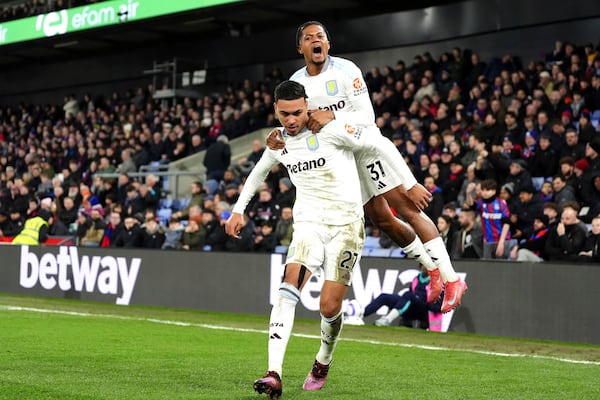 Aston Villa's Morgan Rogers, left, celebrates scoring their side's first goal of the game with teammate Leon Bailey during the English Premier League soccer match between Crystal Palace and Aston Villa at Selhurst Park, London, Tuesday, Feb. 25, 2025. (Zac Goodwin/PA via AP)