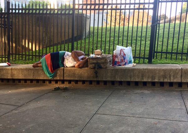 A woman sleeps on the ledge across from Atlanta City Hall. Photo by Bill Torpy