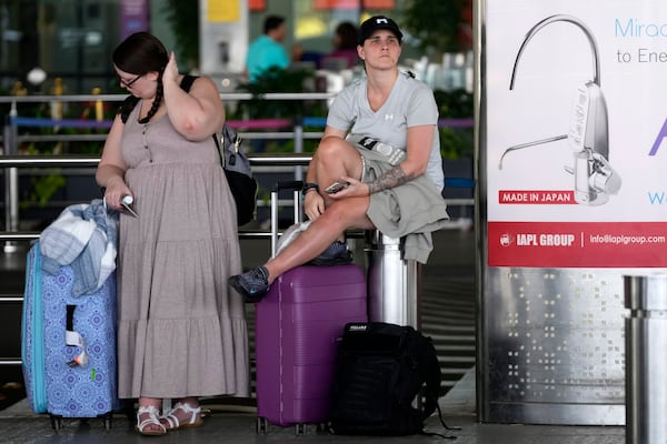 Traveller Lauren Clark, left, and Shahin Jade Ali wait at Chhatrapati Shivaji Maharaj International Airport after a fire at Heathrow Airport in London forced its closure, leading to numerous flight cancellations, in Mumbai, India, Friday, March 21, 2025. (AP Photo/Rajanish Kakade)